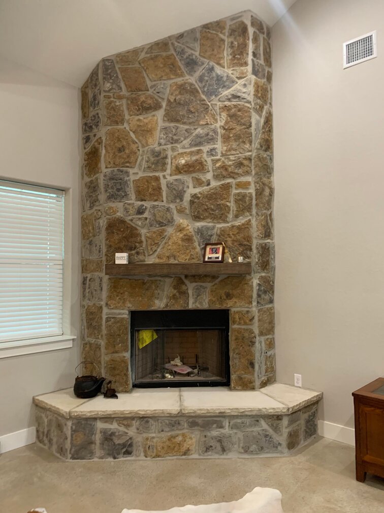Cozy stone fireplace right next to a window