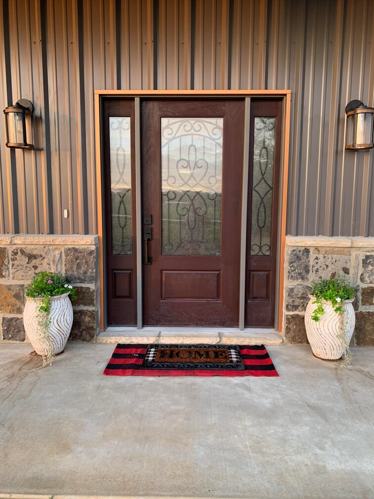 Front door with 2 large plant vase at the sides
