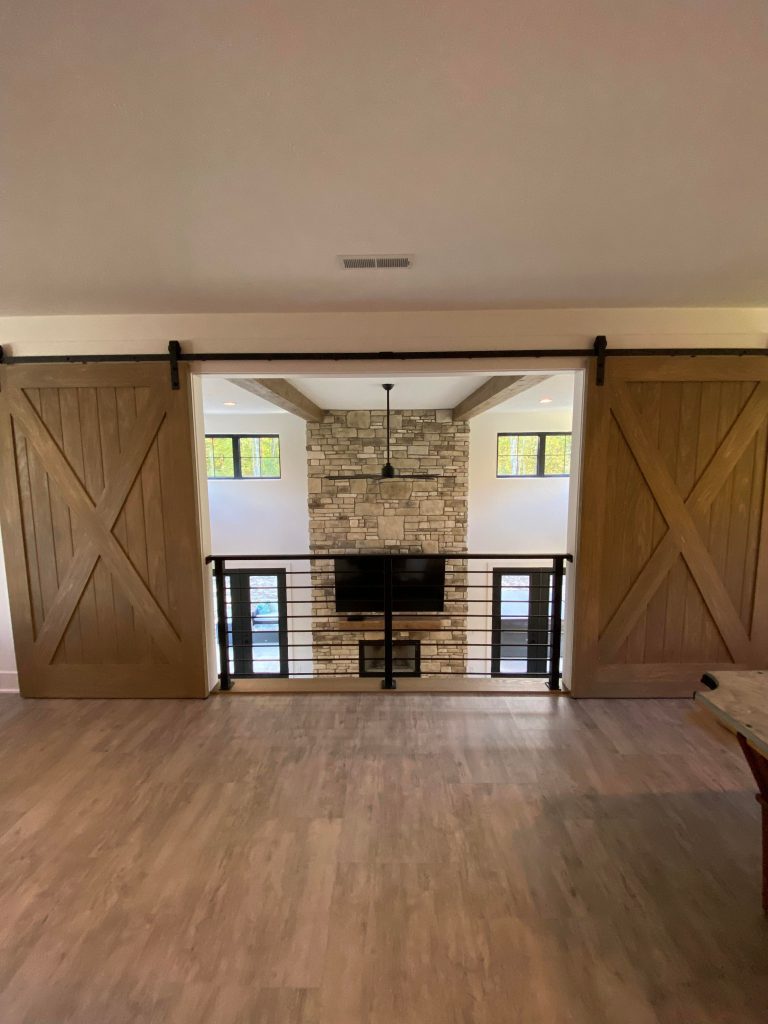 The balcony overlooking the living area, with installed barn doors.