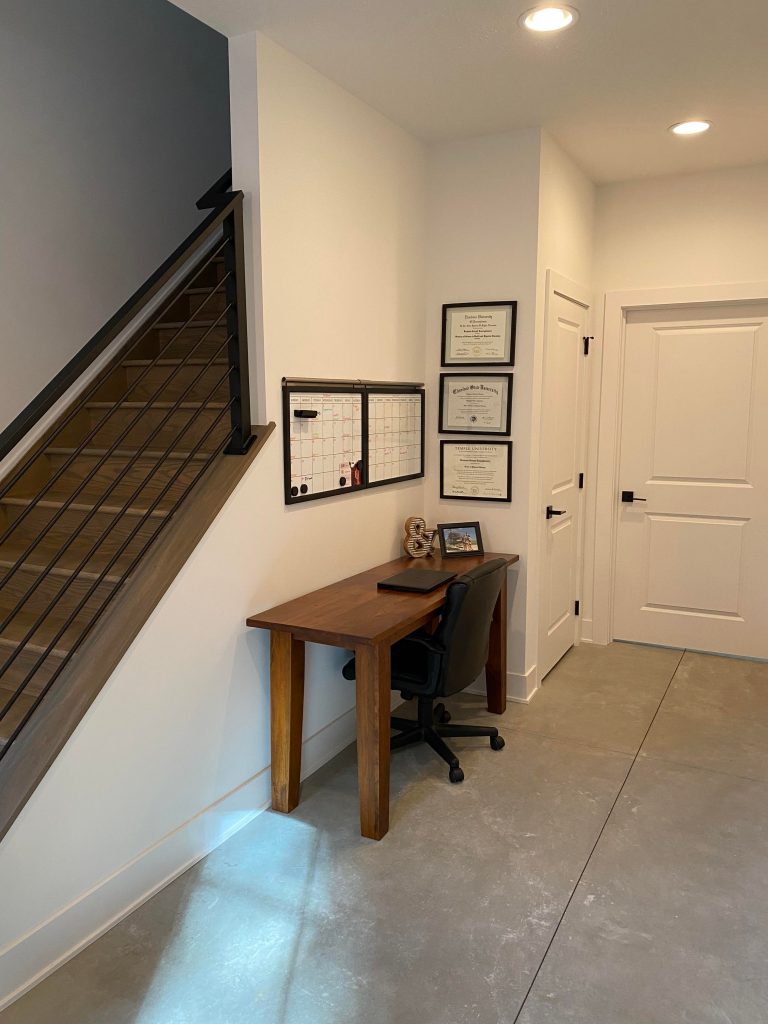 Foyer area with a chair and desk.