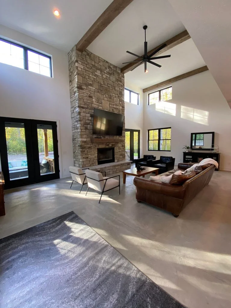 Two-story geat room with a magnificent fireplace and living room setup.