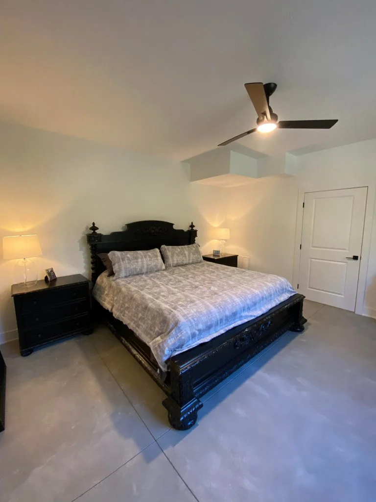 A well lit bedroom with a queen size bed between two nightstands.