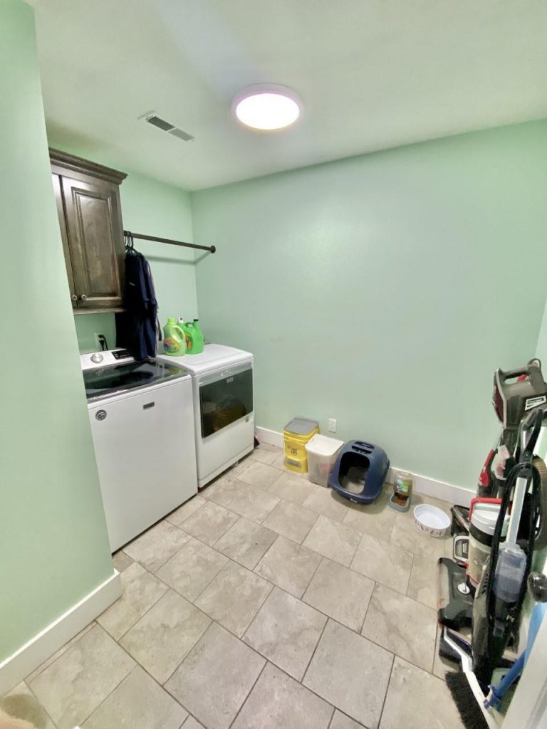Laundry room with wooden shelf