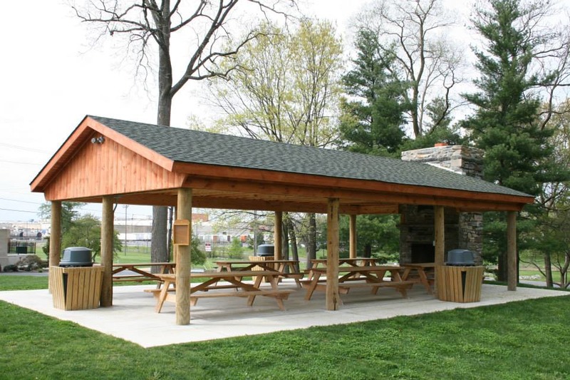An image of a quaint wooden pavilion with a wooden chair, set against the backdrop of a beautiful landscape. The natural wood construction of the pavilion and chair blends well with the outdoor environment, evoking a sense of calm and serenity. The view of the stunning landscape adds to the peaceful and relaxing atmosphere, offering a perfect setting for enjoying nature and taking a break from the daily routine. This may be a public or private space, ideal for outdoor activities or a quiet retreat