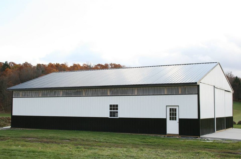 An image of a spacious white agricultural building with a white roof. The building's clean and simple design suggests a practical and functional purpose, such as for storage, processing, or handling of agricultural products. The white roof provides a uniform and cohesive look, while also offering protection from the elements. This may be a commercial or a privately-owned facility, supporting the needs of a farming community.