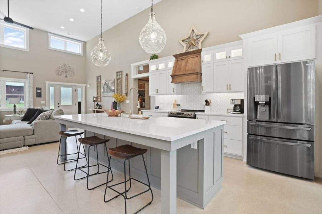 A photograph of a modern and open kitchen with ample space for cooking and entertaining. The kitchen features sleek and minimalist design, with clean lines and a simple color palette. 