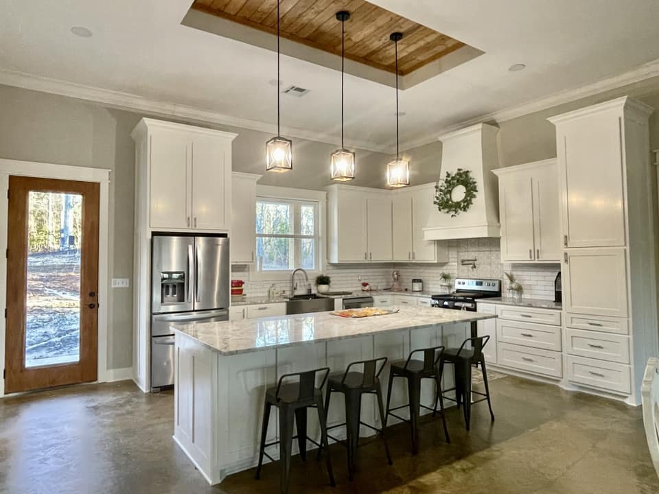 A modern and sleek kitchen with a minimalist design. The kitchen features shiny white countertops and cabinets