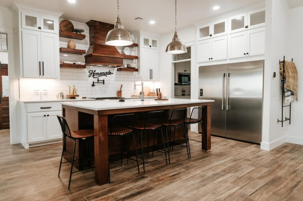 A photograph of a kitchen with a white finish and dark wood accents, creating a modern and sophisticated look. 