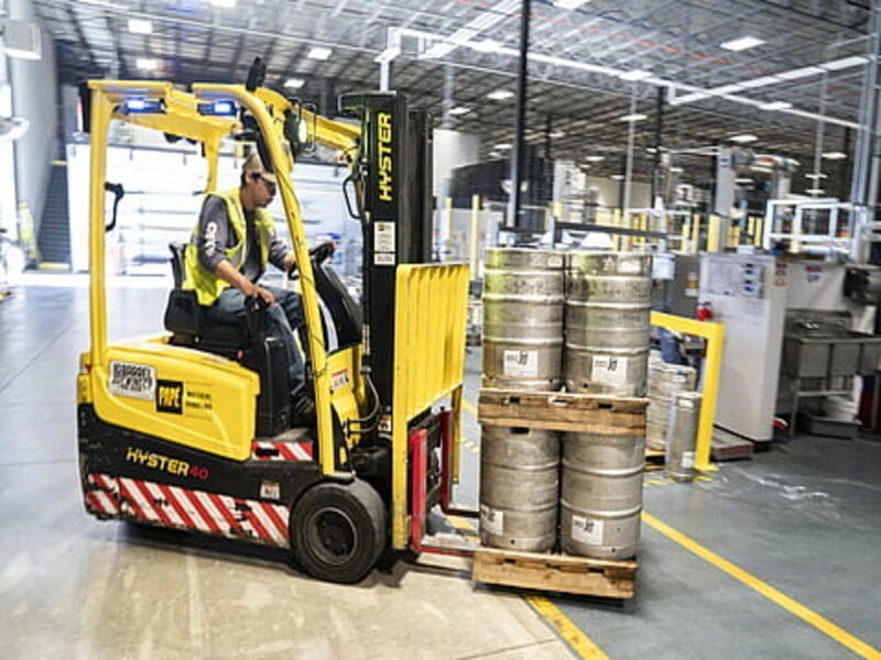 A powerful, heavy-duty forklift with a robust frame and large industrial tires stands tall in a warehouse. 