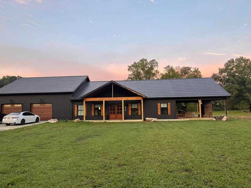 a decent sized shouse that's perfectly captured between the sunset and its field