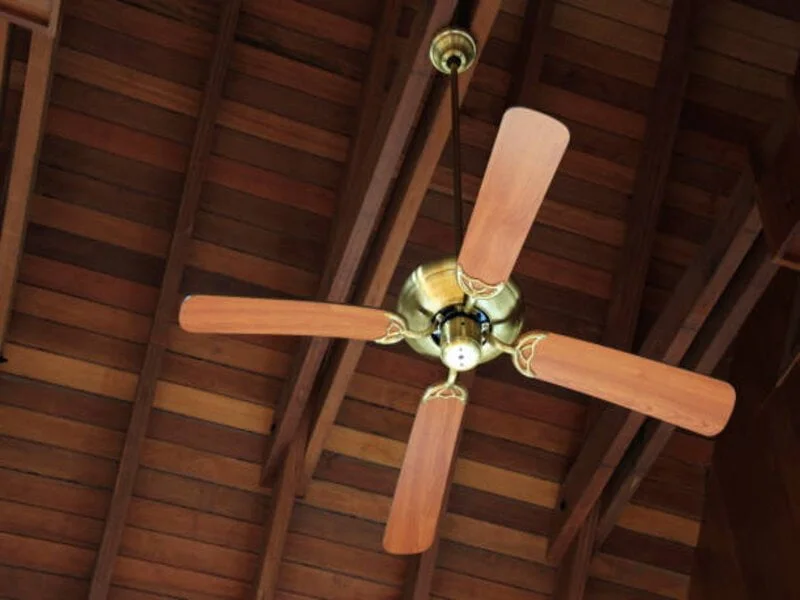 A close-up image of a sleek and modern ceiling fan suspended from the ceiling