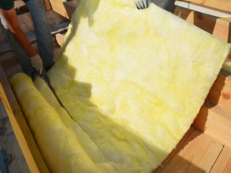 An image showing a blanket batt insulation installation. The insulation material consists of long, flexible sheets of insulation