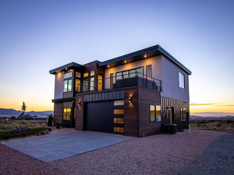 A charming two-story wooden barn stands proudly against a backdrop of lush green fields. 