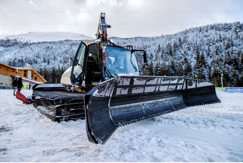 a crawler bulldozer cleaning snow on mountains