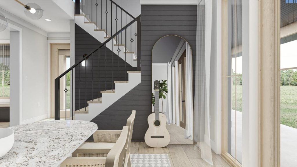 The image shows the side of the dining area where guitar leaning on the full-length mirror and the staircase to the 2nd floor.