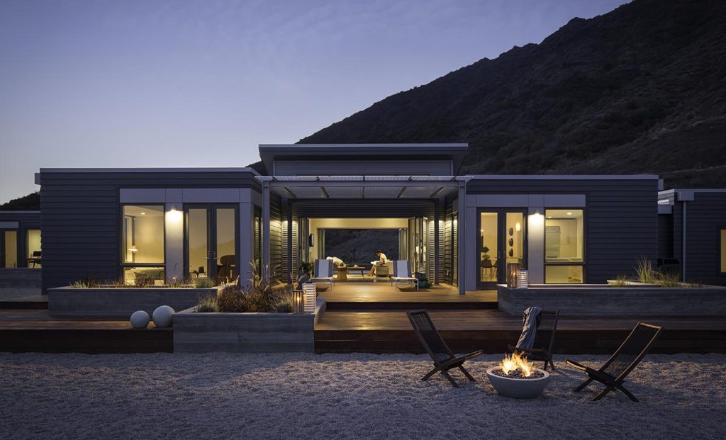 A modern and simple look of a prefab home at night and in sandy texture. Image via bluehomes.com