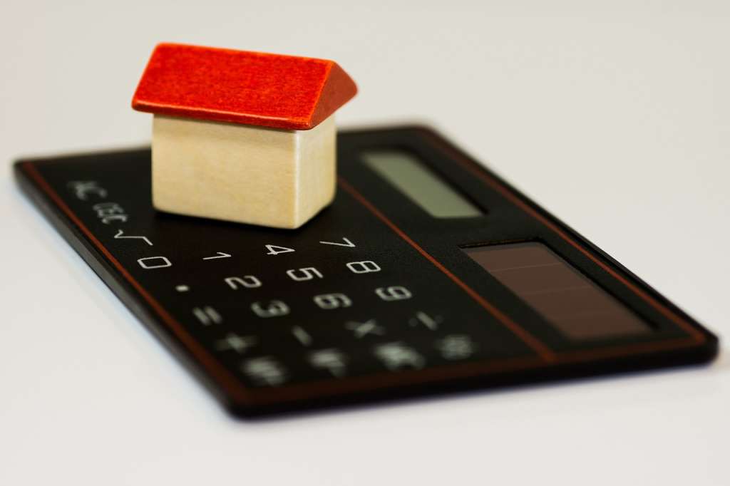 a small 3D house figure on a black calculator indicating home financing