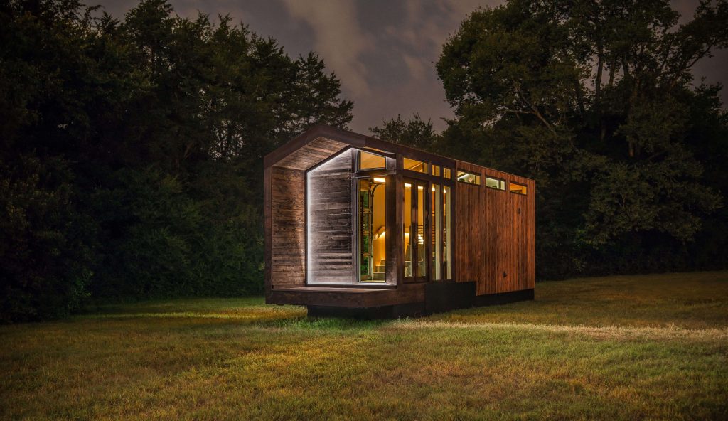 A prefab home that's been surrounded by total darkness as the night sky hovers it still. Image via newfrontierdesign.com