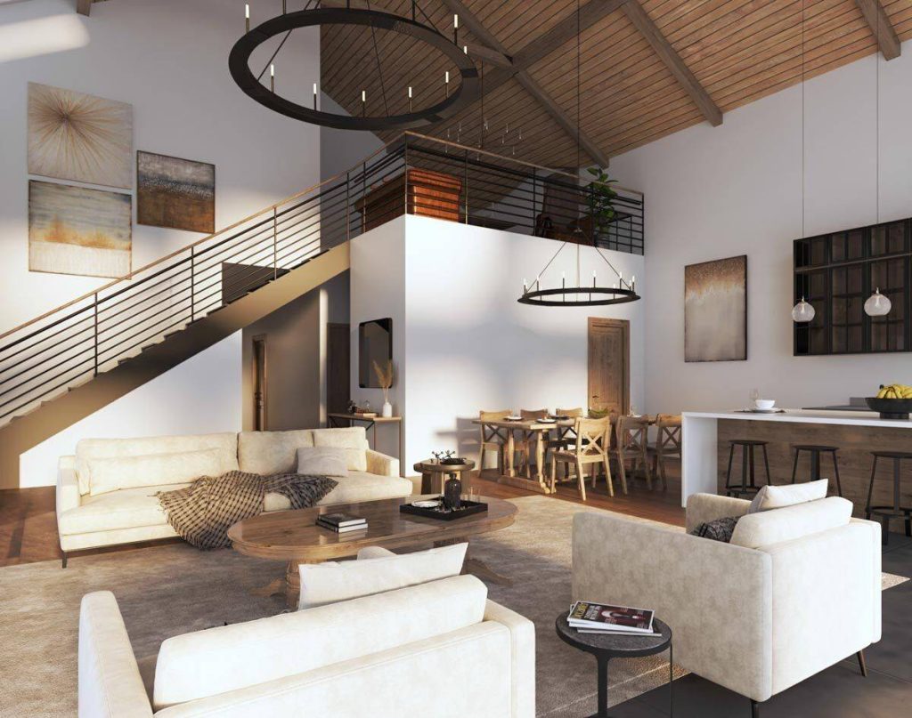 The modern living room of this barndominium, thoughtfully furnished with comfortable couches, chairs, and tables. A staircase ascends gracefully to the second floor, adding a dynamic element to the space. This bright and airy living room is designed with plenty of room for relaxation and entertaining, making it an ideal gathering place.