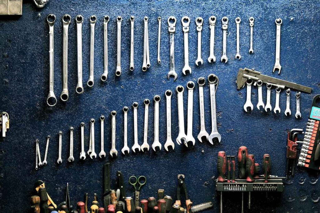 Well-organized tools hanged on a blue garage wall